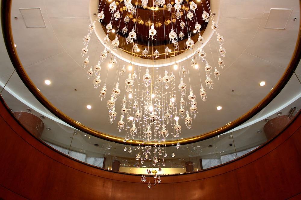 Evergreen Laurel Hotel - Taichung Extérieur photo The photo shows an elegant chandelier hanging from a ceiling. The chandelier features numerous hanging crystals that reflect light, creating a sparkling effect. The ceiling itself is circular and designed with a smooth surface, accented by a circular