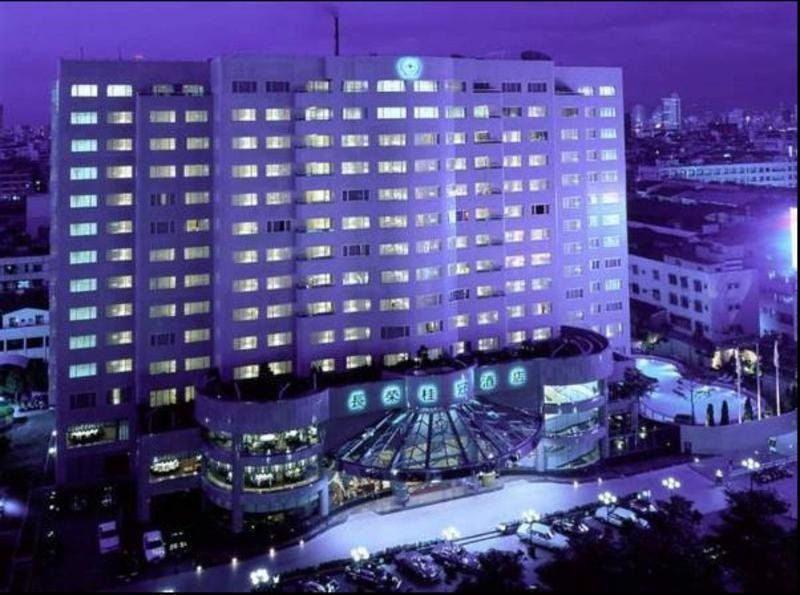 Evergreen Laurel Hotel - Taichung Extérieur photo The photo shows a large hotel building illuminated in a purple hue during the evening or nighttime. The facade features numerous windows, many of which are lit, suggesting occupancy. The entrance area appears modern and curved, with a design that inc