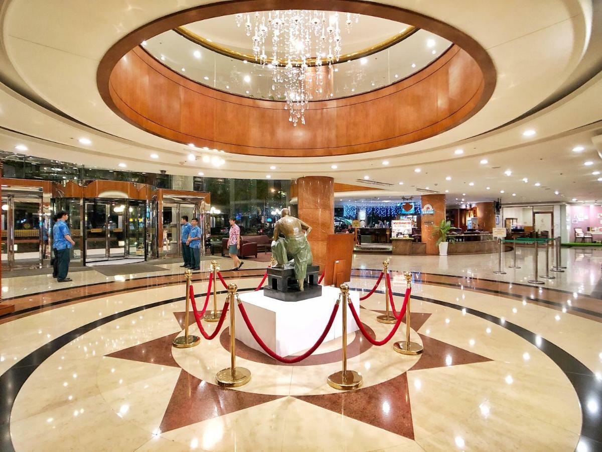 Evergreen Laurel Hotel - Taichung Extérieur photo The image shows a spacious lobby area of a building, likely a hotel or an upscale establishment. The design features a circular ceiling with a chandelier hanging from it, creating a bright and elegant ambiance. At the center, there is a statue, likel