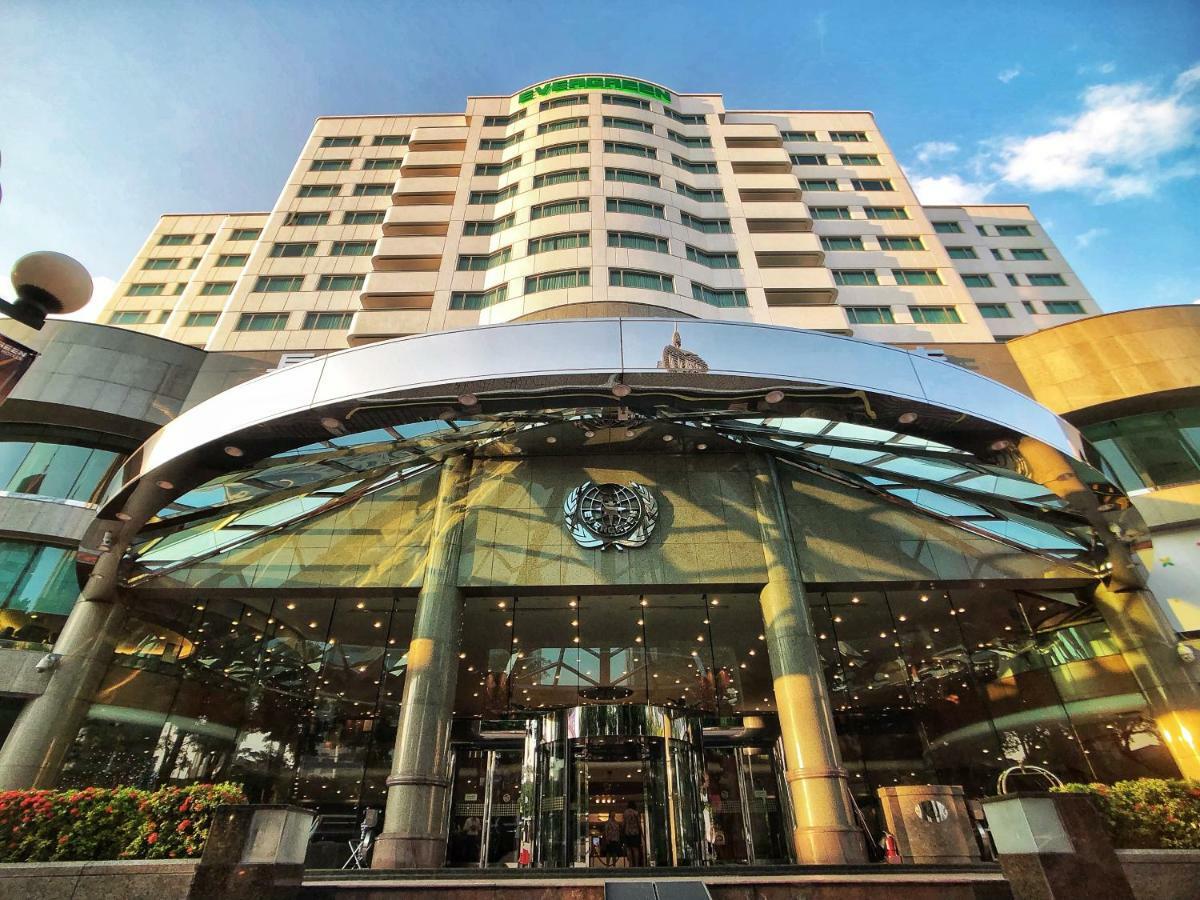 Evergreen Laurel Hotel - Taichung Extérieur photo The photo shows the exterior of a modern hotel building. The entrance features a large, glass canopy supported by columns, creating a welcoming area. The facade of the hotel is composed of a mix of glass and concrete, with large windows that suggest 