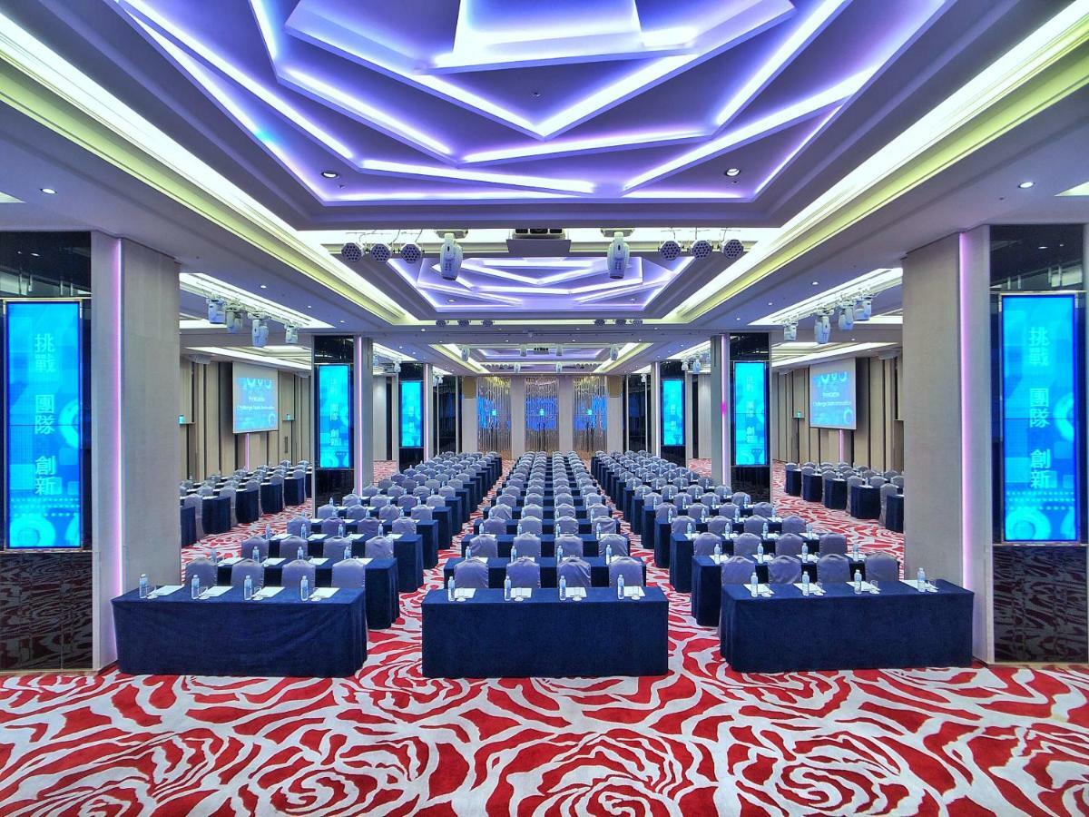 Evergreen Laurel Hotel - Taichung Extérieur photo The photo shows a large conference or seminar room set up for an event. The space features rows of tables and chairs arranged neatly, likely for attendees to participate in discussions or presentations. The room is well-lit with modern, colorful ligh