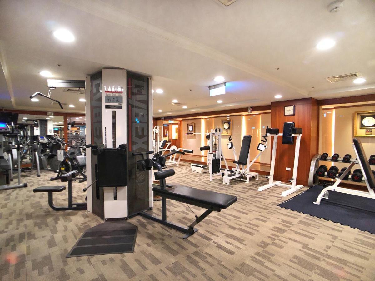 Evergreen Laurel Hotel - Taichung Extérieur photo The photo shows an indoor gym or fitness area. It features various workout equipment, including:

- A multi-station gym machine in the center for strength training.
- Weight benches and free weights organized on shelves.
- Cardio equipment, likely tr